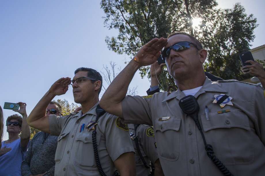 Police stand at attention as a motorcade carrying Ventura Country sheriff Sgt. Ron Helus, who was killed in a shooting at Borderline Bar the night before, passes by outside the Los Robles Medical Center in Thousands Oaks, California on November 8, 2018. - The gunman who killed 12 people in a crowded California country music bar has been identified as 28-year-old Ian David Long, a former Marine, the local sheriff said Thursday. The suspect, who was armed with a .45-caliber handgun, was found deceased at the Borderline Bar and Grill, the scene of the shooting in the city of Thousand Oaks northwest of downtown Los Angeles. Photo: APU GOMES/AFP/Getty Images