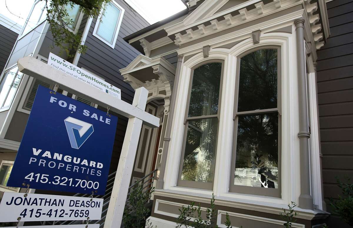 FILE: A sign is posted in front of a home that is for sale in San Francisco, California.