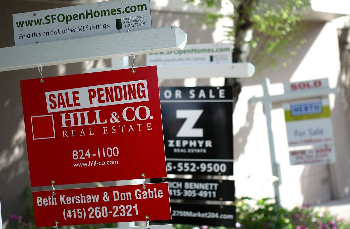 FILE PHOTO: Real estate signs are posted in front of homes for sale in San Francisco, California.