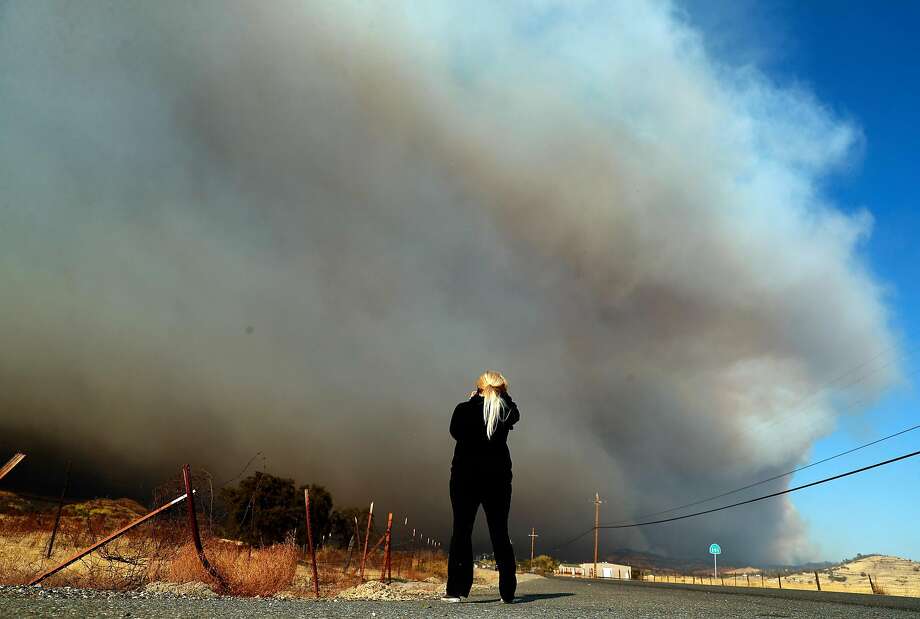 After evacuating from her home in Paradise, Angie Waltmon wipes away a tear while watching Camp Fire from along Highway 191 in Butte County, Calif.. on Thursday, November 8, 2018. Photo: Scott Strazzante, The Chronicle
