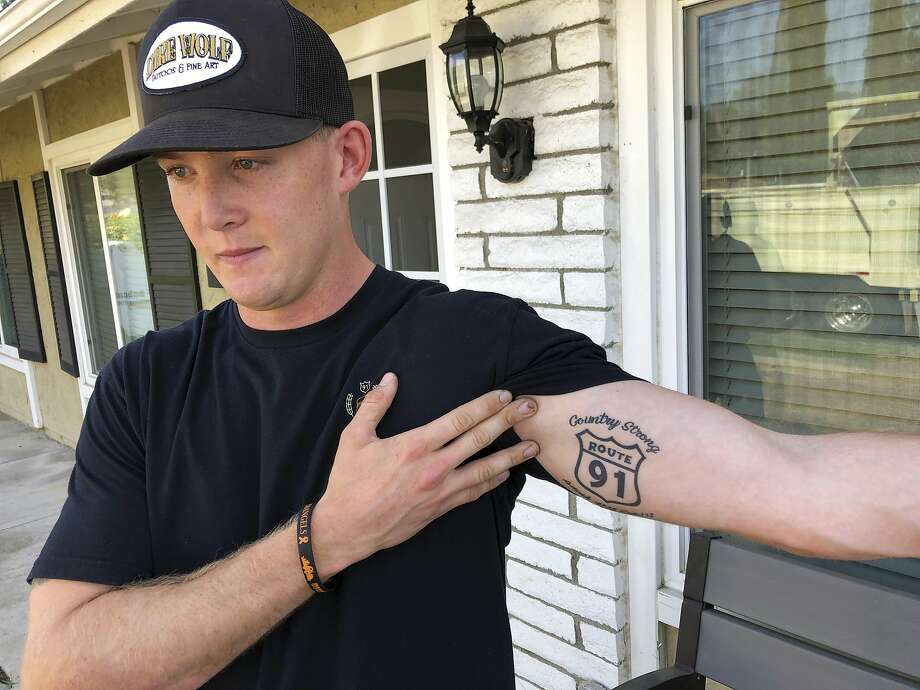 Brendan Kelly speaks with reporters outside his home, as he shows his Route 91 tattoo, Thursday, Nov. 8, 2018, in Thousand Oaks, Calif. Kelly, a Marine who was at Borderline Bar and Grill on Wednesday night, helped people get out after a gunman opened fire at the establishment. Kelly also survived the Las Vegas Route 91 Harvest Festival shooting in 2017. (AP Photo/Ryan Pearson) Photo: Ryan Pearson, Associated Press