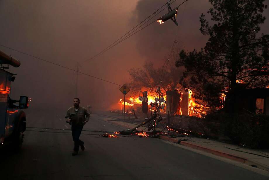 A PG&E worker runs while dealing with downed power lines during Camp Fire in Paradise, Calif.. on Thursday, November 8, 2018. Photo: Scott Strazzante, The Chronicle