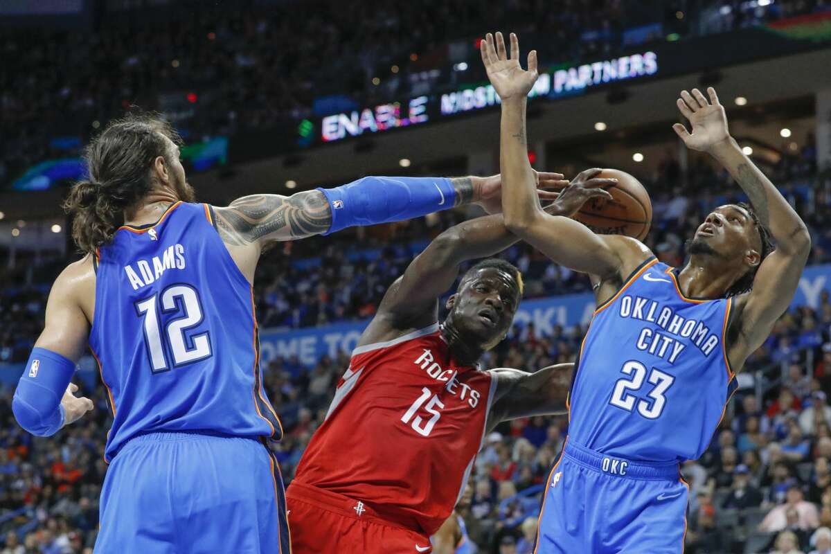 Houston Rockets center Clint Capela (15) works to get a shot off as Oklahoma City Thunder center Steven Adams (12) and guard Terrance Ferguson (23) defend during the second half of an NBA basketball game Thursday, Nov. 8, 2018, in Oklahoma City. Oklahoma City won 98-80. (AP Photo/Alonzo Adams)