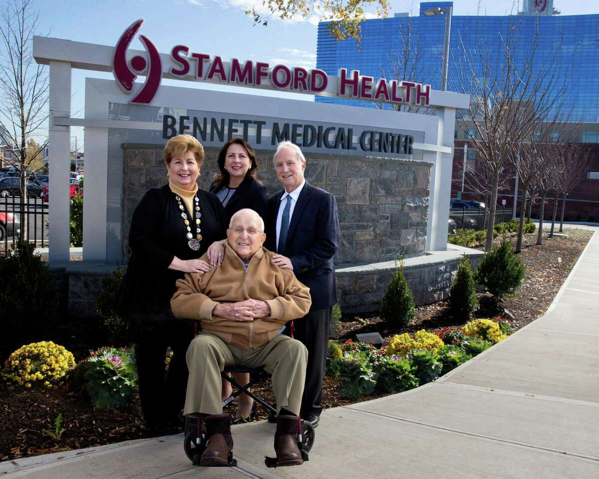 New signs have been installed at the main West Broad Street entrance to Stamford Hospital, whose campus is also known as the Bennett Medical Center. The Bennett family has given a total of more than $20 million to the hospital. In front center is Carl Bennett. In back, from left, are Robin Bennett-Kanarek, daughter of Carl Bennett; Kathy Silard, CEO of the Stamford Health system; and Marc Bennett, son of Carl Bennett.