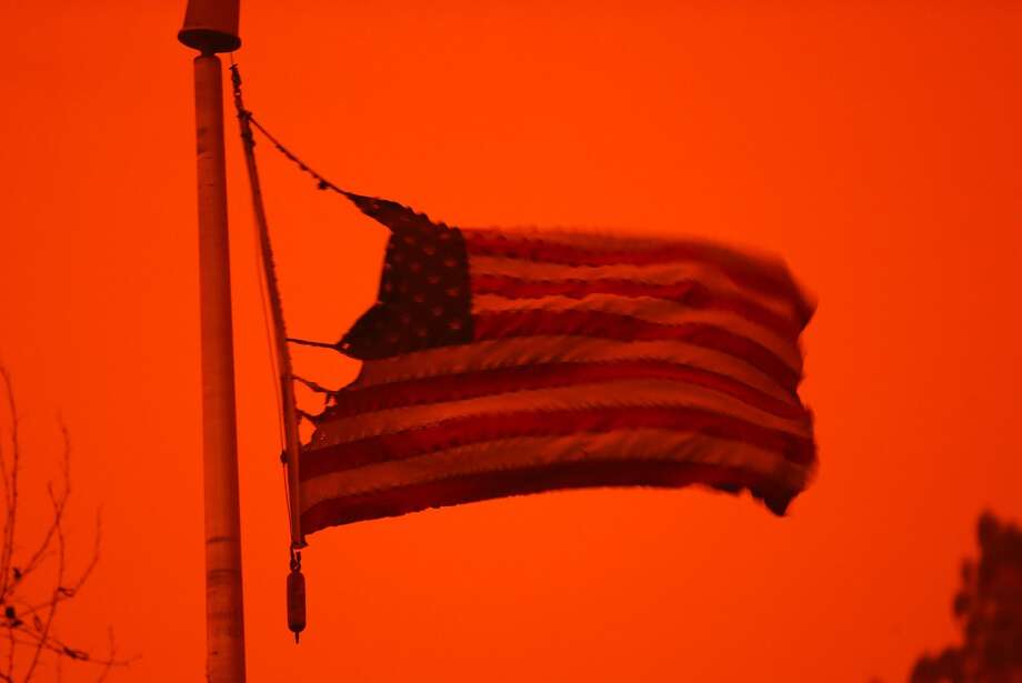 A partially burned flag flies during Camp Fire in Paradise, Calif. on Friday, November 9, 2018. Photo: Scott Strazzante, The Chronicle
