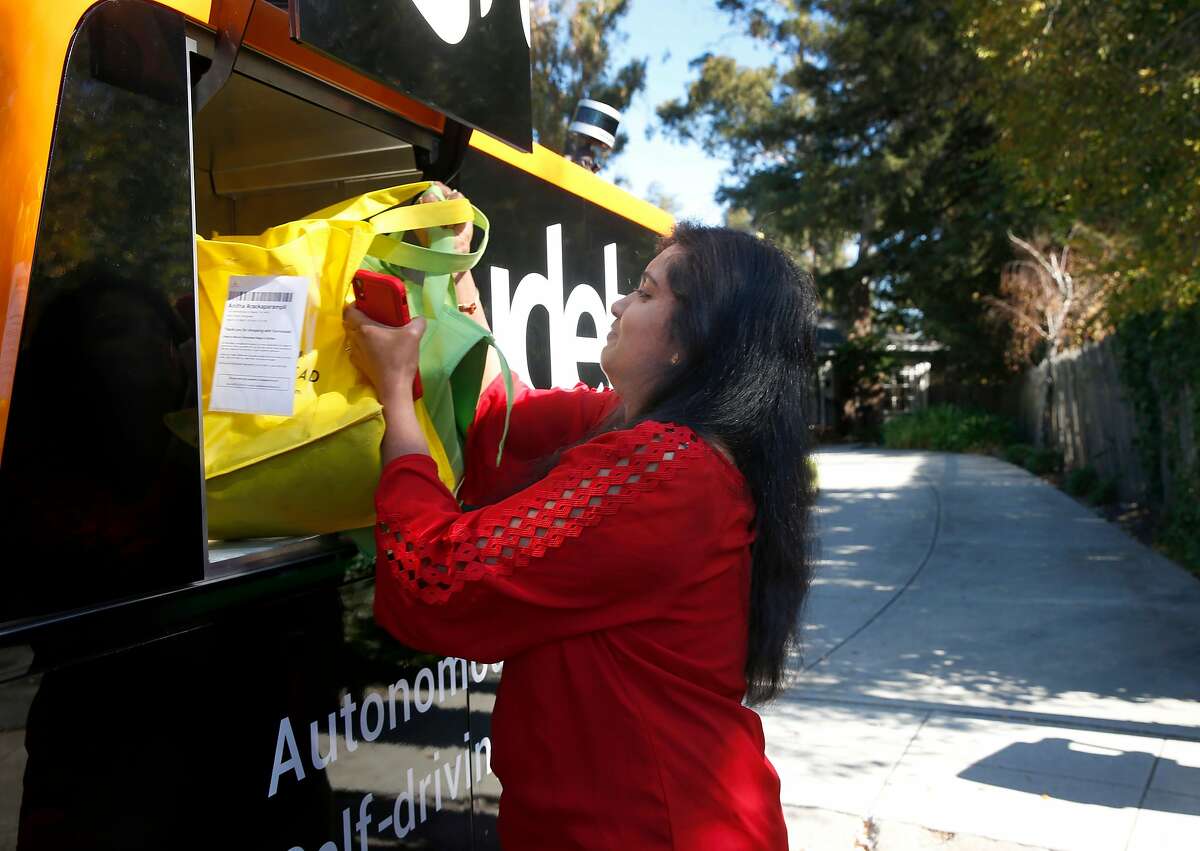 Anitha Arackaparampil removes groceries from Farmstead delivered to her home by a Udelv autonomous van in Burlingame, Calif. on Wednesday, Nov. 7, 2018. Udelv’s four driverless vans provide delivery service for several vendors and hopes to have a fleet of 100 vehicles by sometime next year.