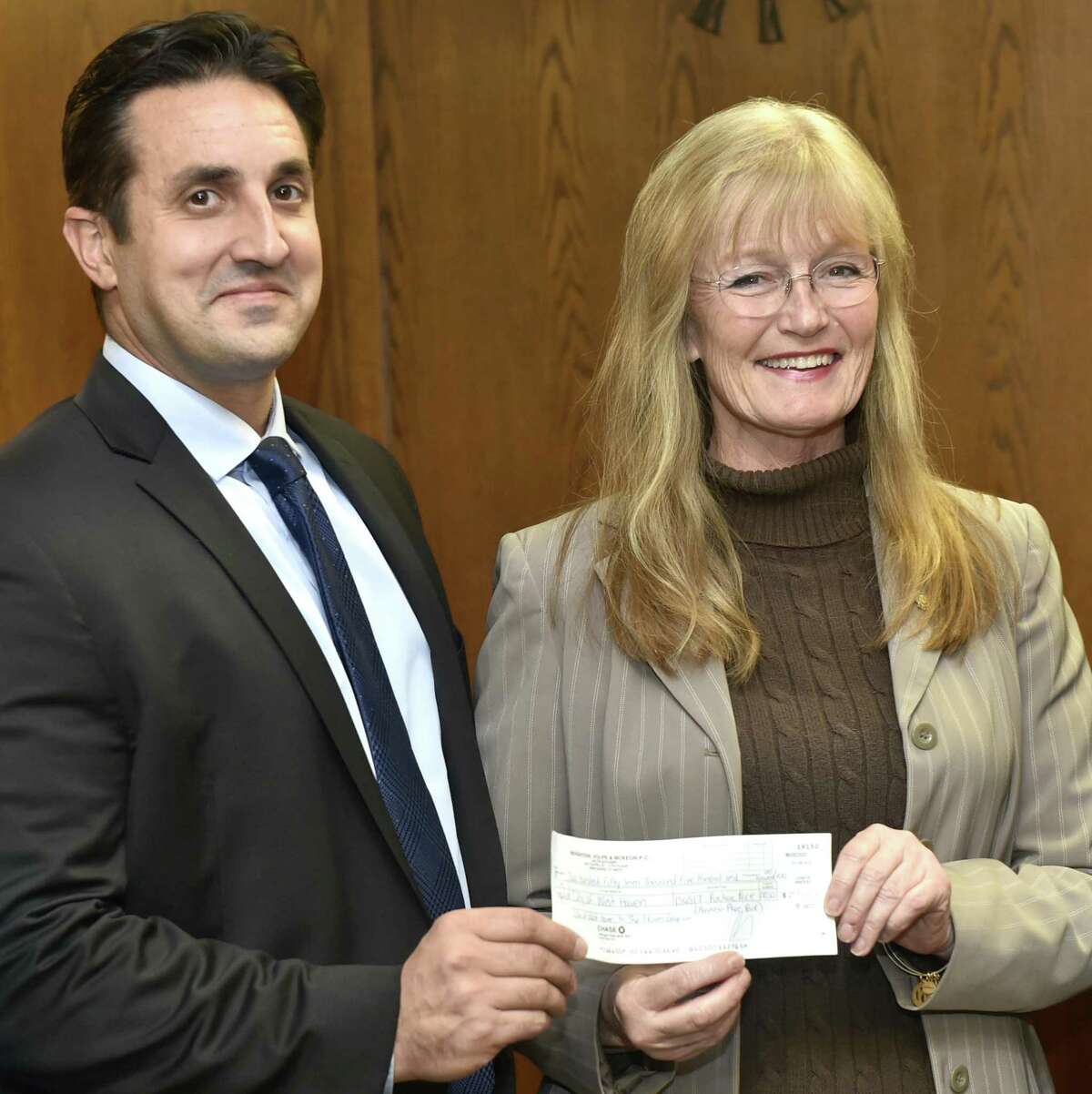 West Haven Mayor Nancy Rossi, right, and Finance Director Ronald Cicatelli hold a $257,500 check Friday at West Haven City Hall, the proceeds of the city’s sale of Bayview Park to The Haven Group.