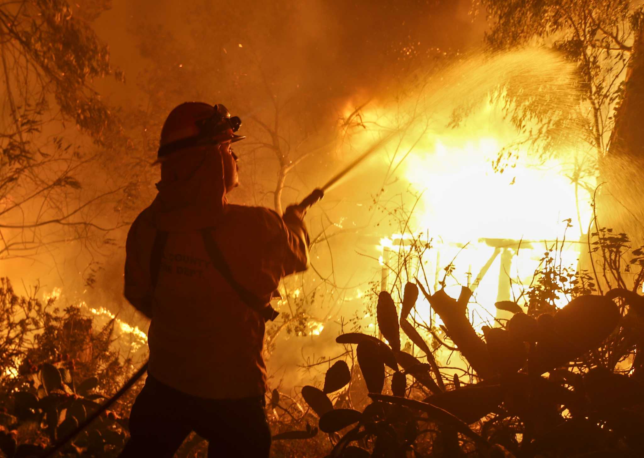 Archive image of wildfire suppression in California Firefighter facing flames during a previous California wildfire; archive image and not a current photograph of the Bryson Fire