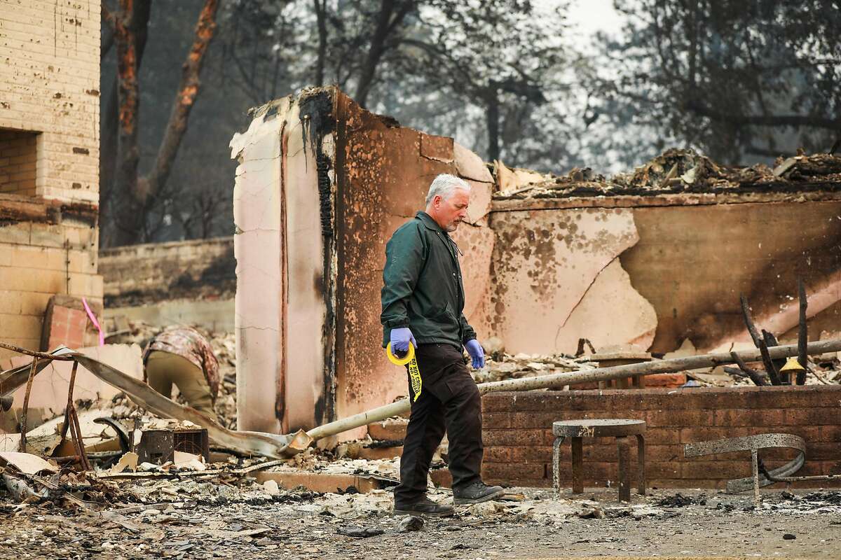 A Butte County Sheriff looks for fatalities following the Camp Fire in Paradise, California, on Saturday, Nov. 10, 2018.