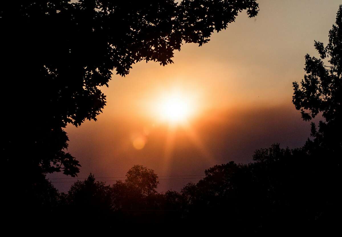 The sun peeks over a wall of smoke wafting through Chico, Calif. from the large Camp Fire Sunday, Nov. 11, 2018.