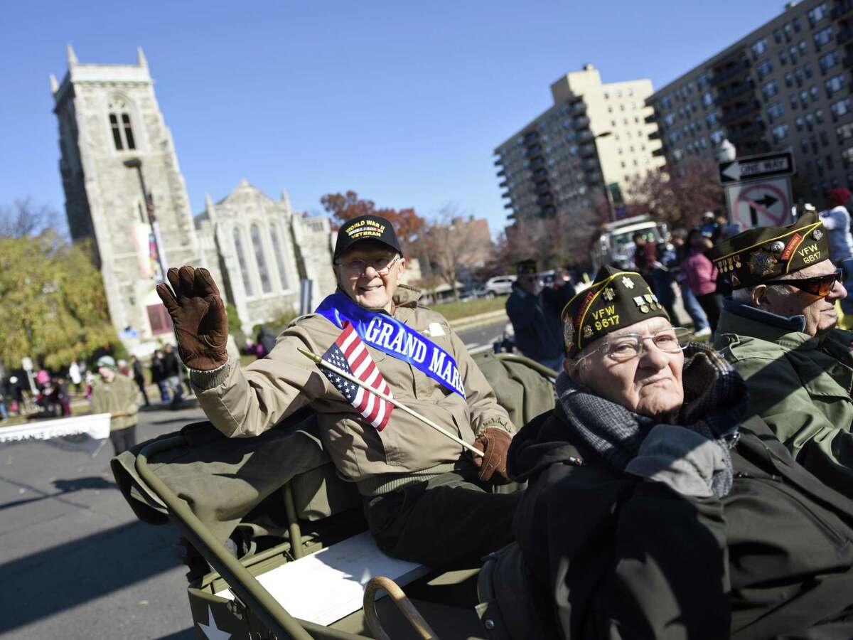 Army aircraft mechanic and flight engineer Sgt. Ted Ogonek, 92, waves to the crowd as grand marshal in the annual Stamford Veteran’s Day Parade, commemorating 100 years since the end of WWI, in Stamford on Sunday.