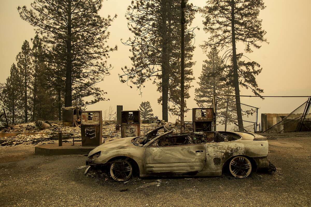 As the Camp Fire burns nearby, a scorched car rests by gas pumps near Pulga, Calif., on Sunday, Nov. 11, 2018. (AP Photo/Noah Berger)