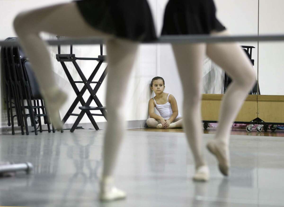 Talia Todd, 7, watches as dancers with the Children's Ballet of San Antonio stretch before the start of rehearsal.