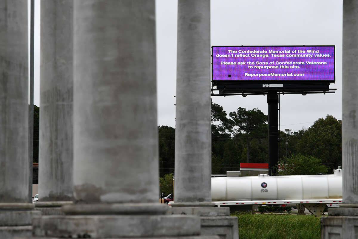 A billboard seen through the Confederate monument in Orange requests that the monument be repurposed. Photo taken Monday, 11/12/18