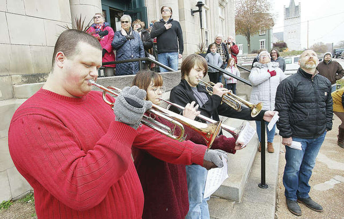Trumpet players from the Alton High School Marching 100 play Monday at a ceremony to raise the American flag above the Post Commons for the first time in more than 50 years.