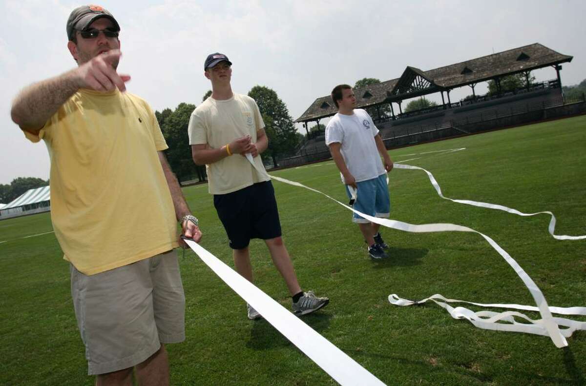 Brandon Lacoff, Tim Bellantoni and Chris Cutler spend Friday afternoon lining the Greenwich Polo Club field with 20 Wiffle ball fields for tomorrow's tournament, which will host close to 60 teams.