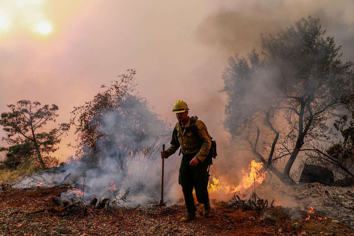 Hotshot firefighter works to stave off the Camp Fire as it burns off of Pentz Road in Paradise, California, on Thursday, Nov. 8, 2018.