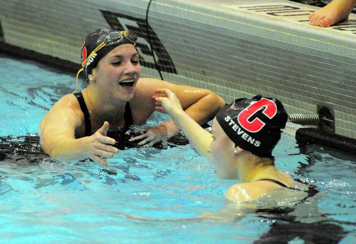 Cheshire’s Samantha Grenon reaches out to hug teammate Julia Stevens after the 500 meter freestyle at the Class L state championship meet on Tuesday.