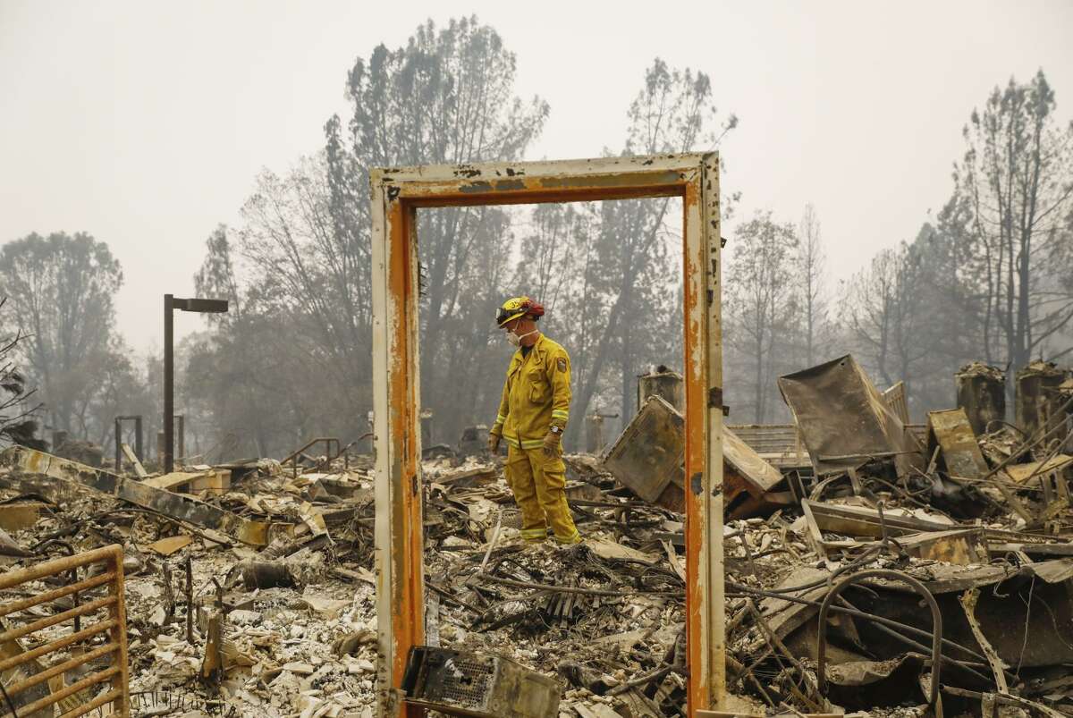 Paradise Firefighter Mike Rea surveys a property for remains at the Paradise Community Village Apartments.