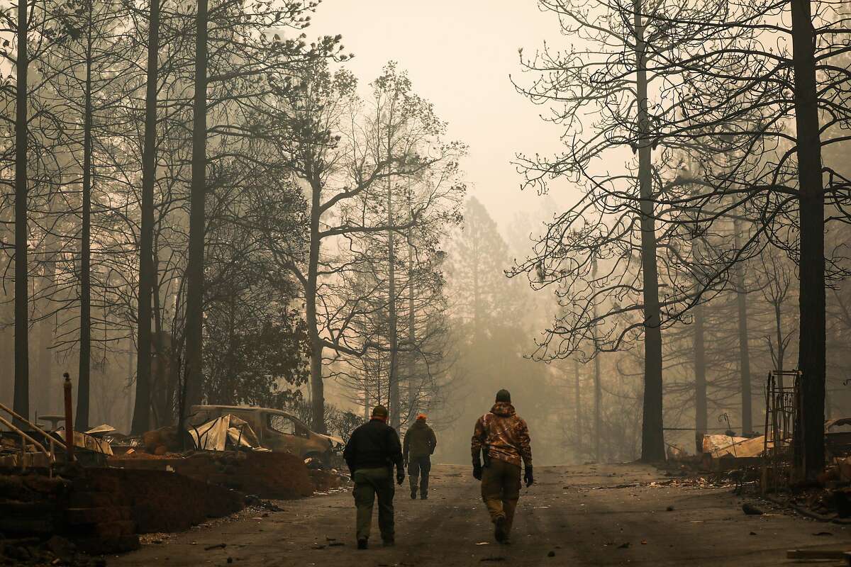 Yuba County Sheriffs walk back to their cars after discovering a fatality following the Camp Fire in Paradise, California, on Saturday, Nov. 10, 2018.