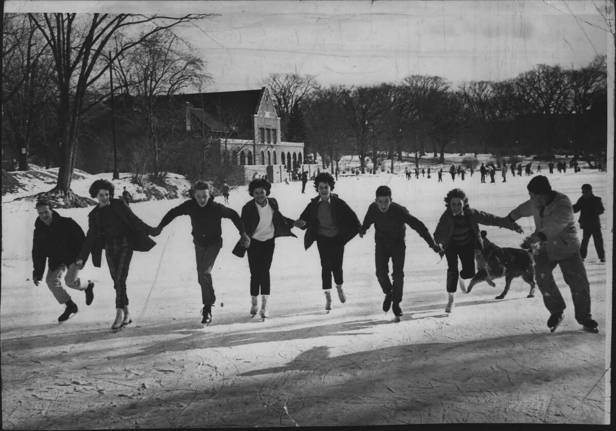 Group of people hold hands as they ice skate at Washington Park Lake, Albany, New York. January 15, 1962 (Knickerbocker News Staff Photo/Times Union Archive)