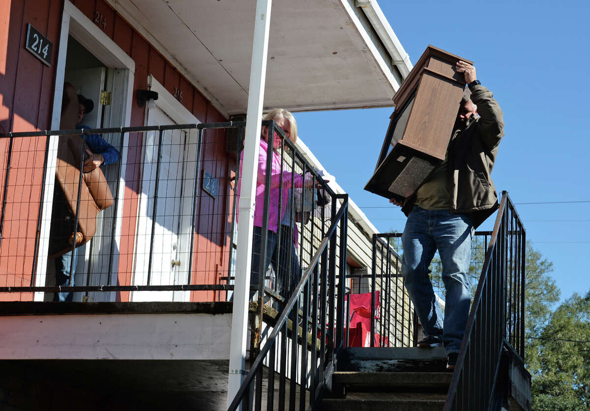 Jason Welch, right, hauls furniture Wednesday from his Vidor apartment which was damaged during a fire Tuesday night. Sixteen units at the American Village Apartment are now inhabitable from the fire. Mark Welch and Sandy Welch are also pictured. Photo taken Wednesday, 11/14/18