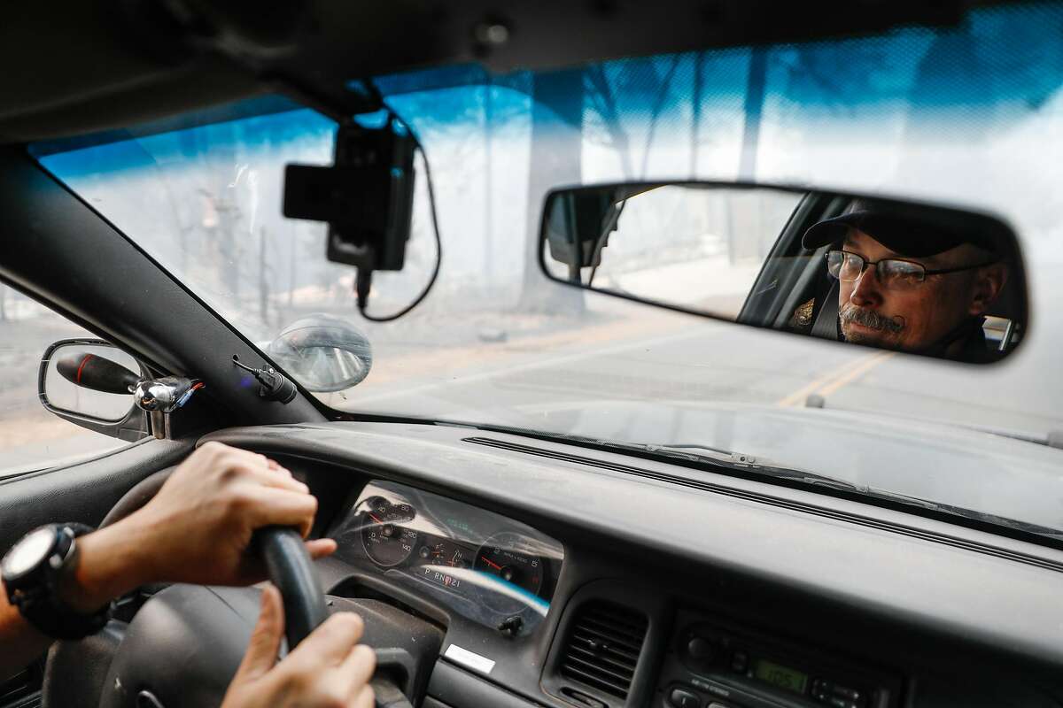 Sgt. Robert Pickering is seen in the mirror while patrolling following the Camp Fire in Paradise, California, on Wednesday, Nov. 14, 2018.