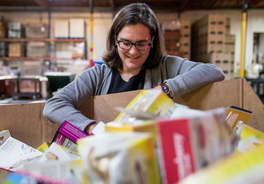 Dr. Hilary Seligman, director of the Food Policy, Health & Hunger Program at San Francisco General Hospital, sifts through a variety of food products scheduled to be distributed inside the Alameda County Community Food Bank in Oakland, Calif. Friday, Oct. 26, 2018. Photo: Jessica Christian / The Chronicle