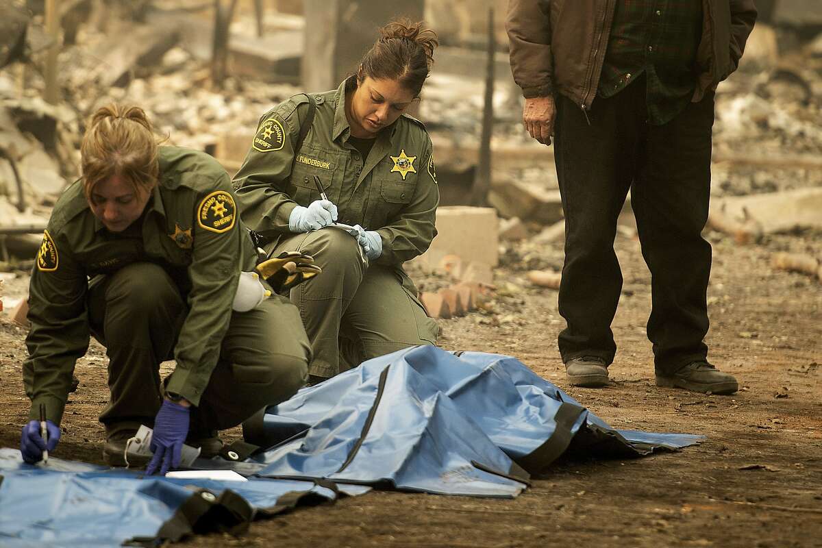 Sheriff's deputies recover the bodies of multiple Camp Fire victims at the from a Holly Hills Mobile Estates residence on Wednesday, Nov. 14, 2018, in Paradise, Calif. (AP Photo/Noah Berger)