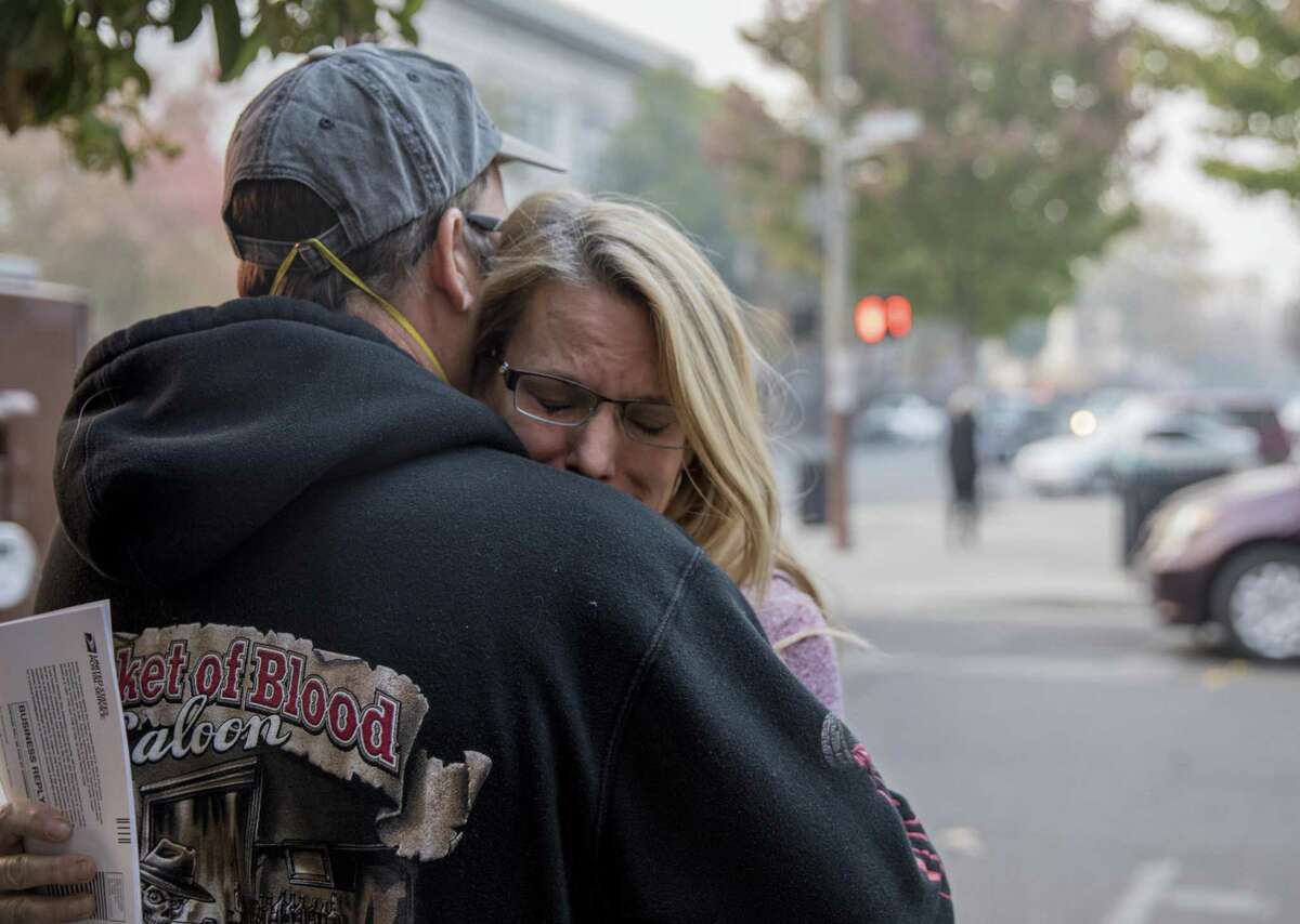 Bill Wilson comforts his wife, Charlotte Wilson, while in line outside of the Chico Post Office in Chico, Calif. Wednesday, Nov. 14, 2018 to change their address after losing their Paradise home in the Camp Fire.