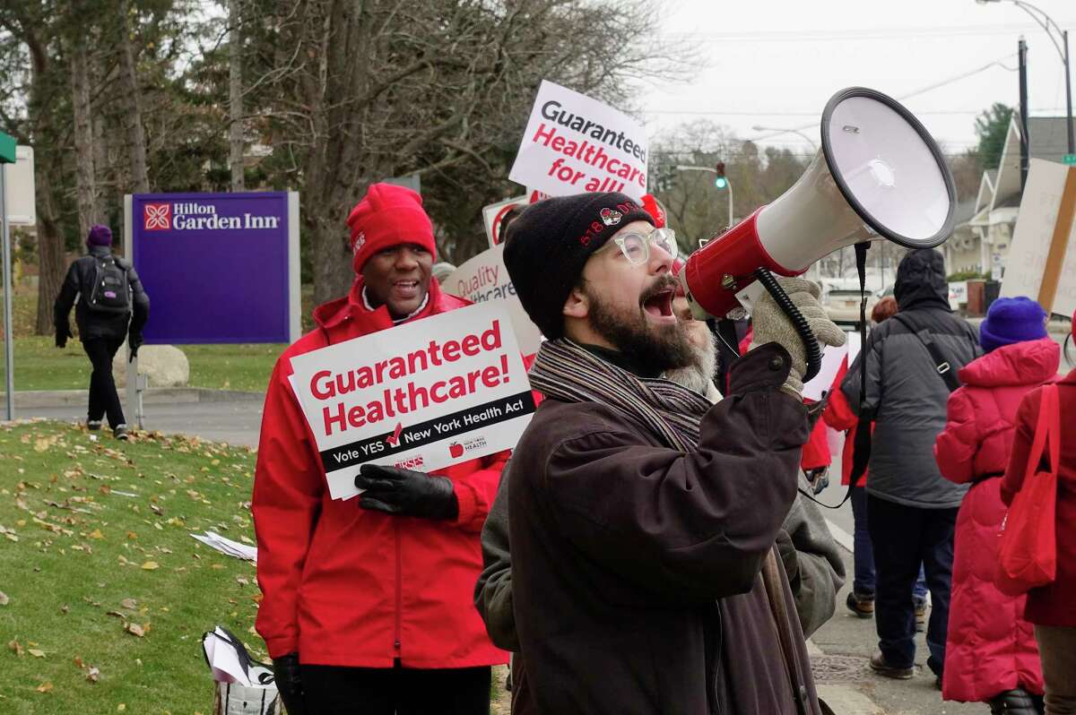 Members of unions, activist groups and healthcare professionals take part in a protest calling for single-payer healthcare outside the Hilton Garden Inn on Thursday, Nov. 15, 2018, in Troy, N.Y. The annual New York Health Plan Association was holding a conference at the hotel. Those protesting say that the New York Health Plan Association is lobbying against the New York Health Act, which would create a single-payer healthcare system in the state. (Paul Buckowski/Times Union)