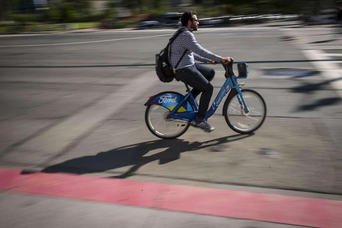 A cyclist rides a Ford GoBike in San Francisco, California, U.S., on Monday, June 11, 2018. Lyft Inc. is in discussions to acquire Ford GoBike and Citi Bike operator Motivate for $250 million, a person familiar with the matter said. The acquisition, if it goes through, would thrust the second-largest U.S. ride-hailing company into the middle of the brewing war over electric scooters and bikes that's beginning to roil American cities. Photographer: David Paul Morris/Bloomberg