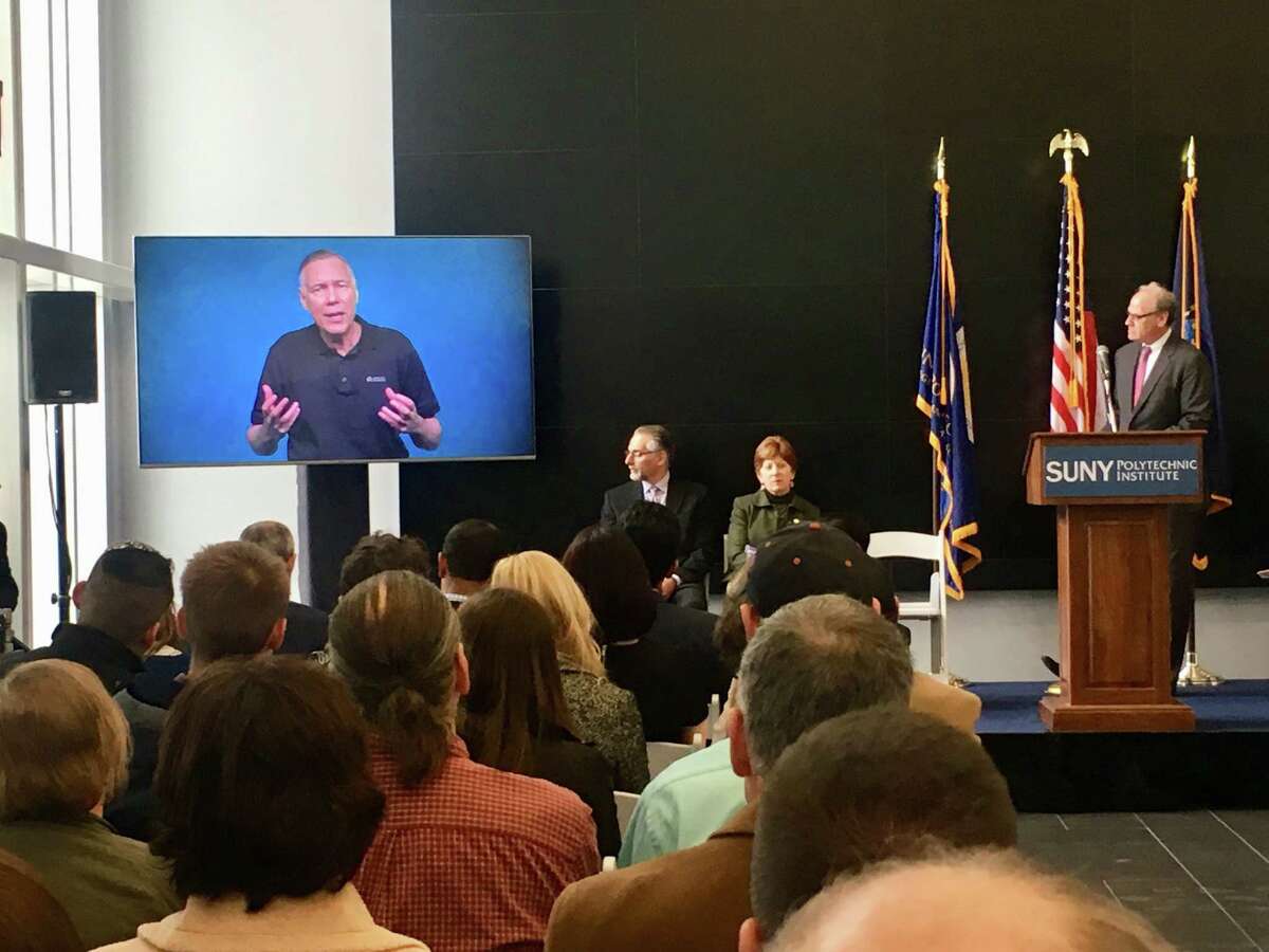 Applied Materials CEO Gary Dickerson appears via video during a press conference on Nov. 15, 2018 at SUNY Polytechnic Instutute's ZEN Building. Applied Materials is planning to fund a $600 million research center at SUNY Poly. The state will kick in $250 million to equip the center. At far right is Howard Zemsky, CEO of Empire State Development, New York's economic development arm.