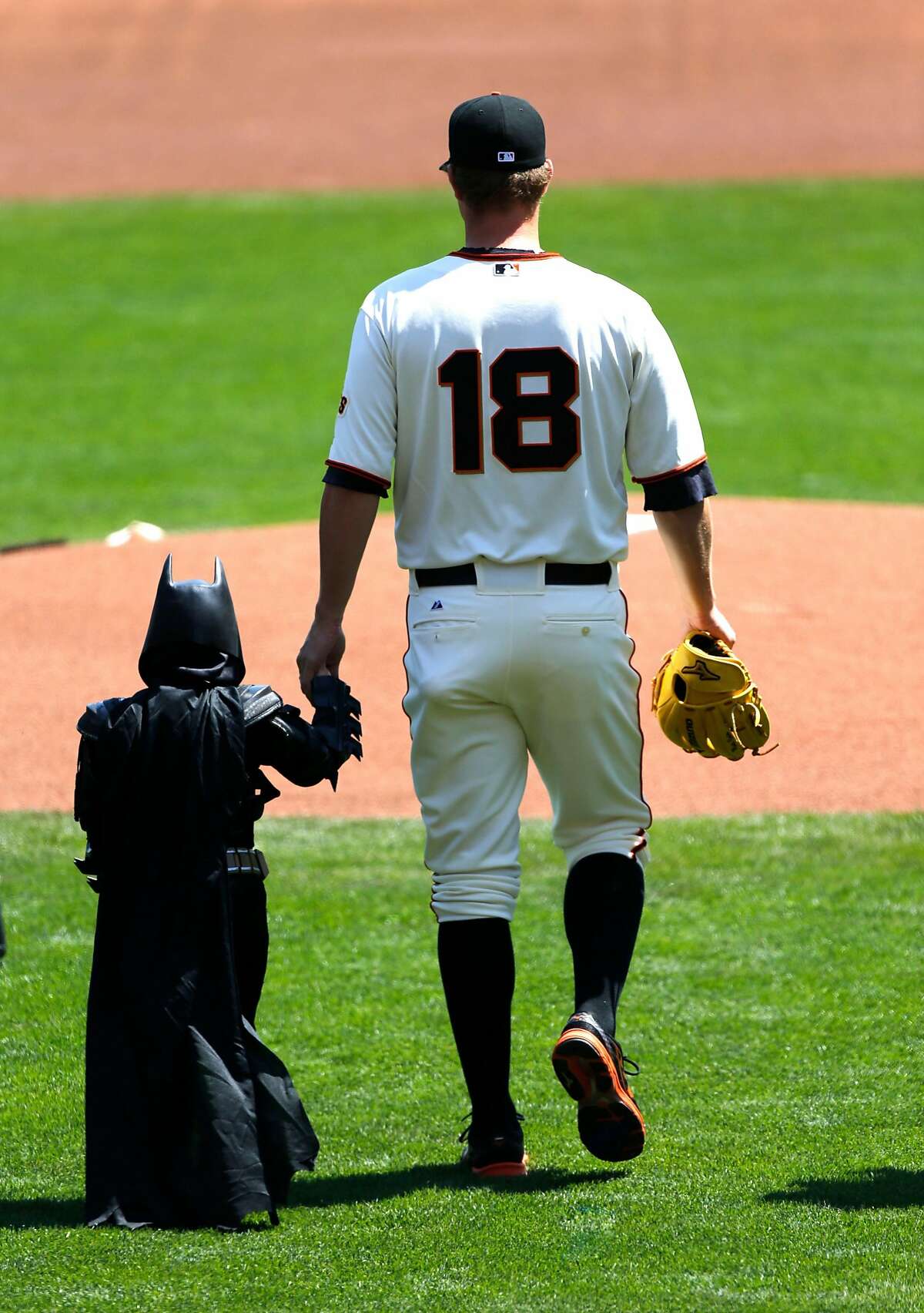 Giants' pitcher Matt Cain leads "Bat kid" out to the mound to throw the first pitch during opening ceremonies as the San Francisco Giants prepare to take on the Arizona Diamondback during their home opener at AT&T Park on Tuesday April 8, 2014, in San Francisco, Calif.