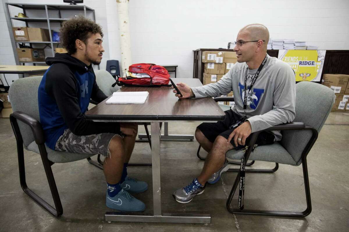 Coach Richard Lazarou, right, mentors senior Vaughnte Frederick at Willowridge High School’s Resource Center, which was set up by Loving Houston volunteers. The nonprofit creates a framework that allows churches to volunteer and provide resources to public schools.