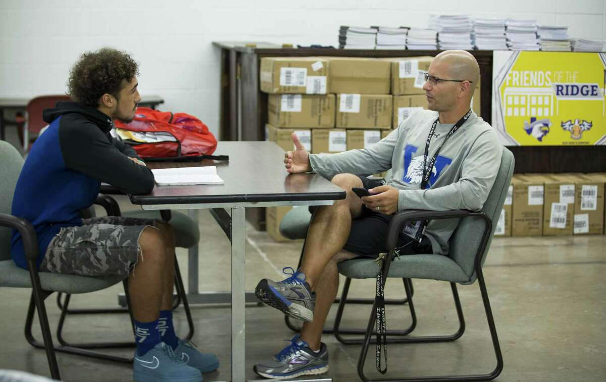 Coach Richard Lazarou sits down and talks to Vaughnte Frederick as he mentors the senior in the Willowridge High School ?“Resource Center,?” which was set up by Loving Houston volunteers, on Wednesday, Sept. 26, 2018, in Houston. Loving Houston is a nonprofit organization that creates a framework that allows churches to volunteer and provide resources to public schools.
