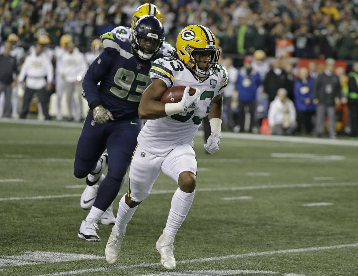 Green Bay Packers running back Aaron Jones, right runs for a touchdown as Seattle Seahawks defensive end Branden Jackson (93) gives chase during the first half of an NFL football game Thursday, Nov. 15, 2018, in Seattle. (AP Photo/Elaine Thompson)