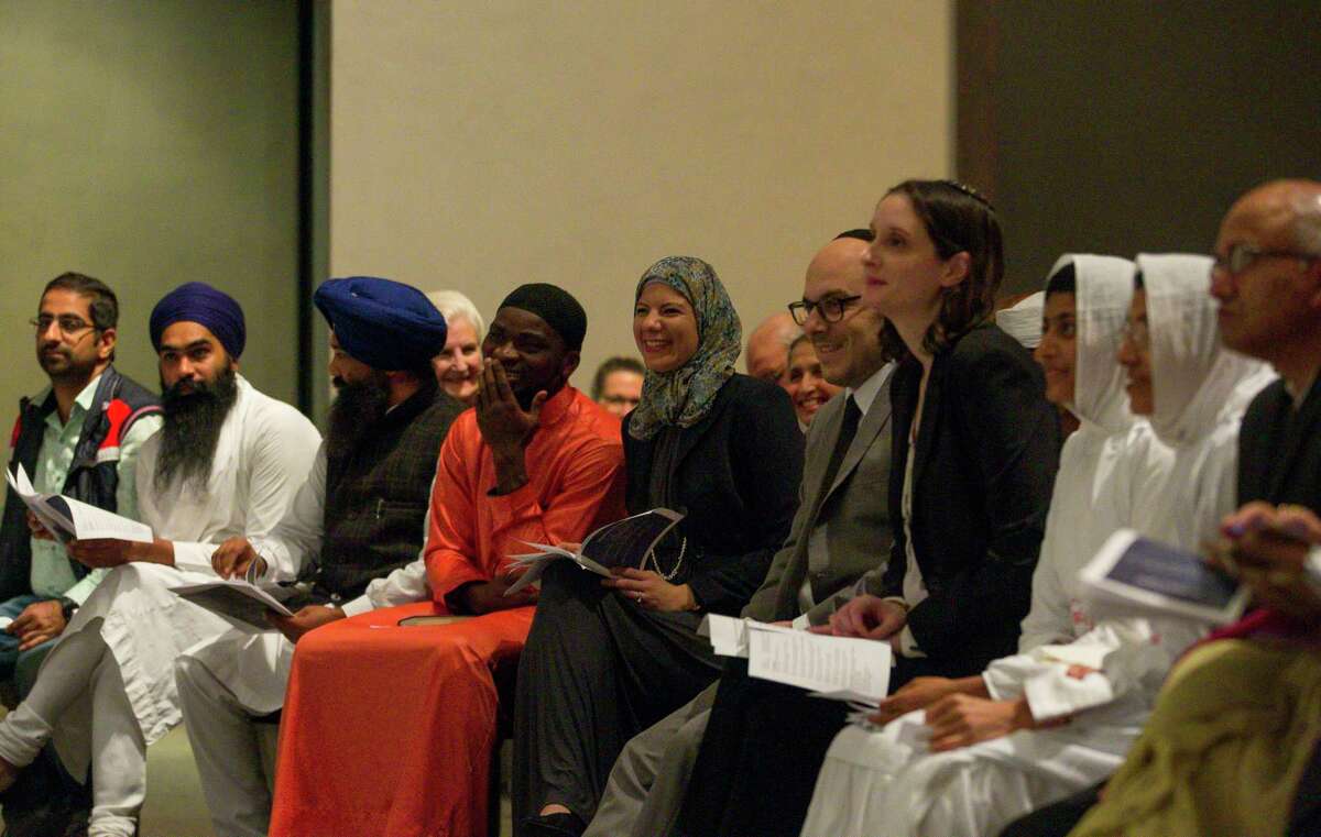 Members of different faith traditions laugh at a joke during the 34th Annual Houston Interfaith Thanksgiving Service at the Rothko Chapel in Houston, Thursday, Nov. 15, 2018. Leaders and members from myriad faith traditions including Baha’i, Buddhist, Christian, Hindu, Jain, Jewish, Muslim, Sikh, and Zoroastrian were invited to share prayer or reflection on the theme “care for creation.”