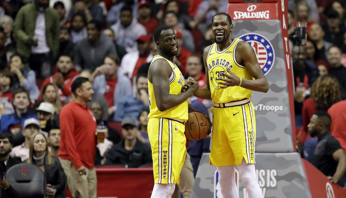 Golden State Warriors' Kevin Durant (35) talks with Draymond Green after a turnover during the second half of an NBA basketball game against the Houston Rockets Thursday, Nov. 15, 2018, in Houston. (AP Photo/David J. Phillip)