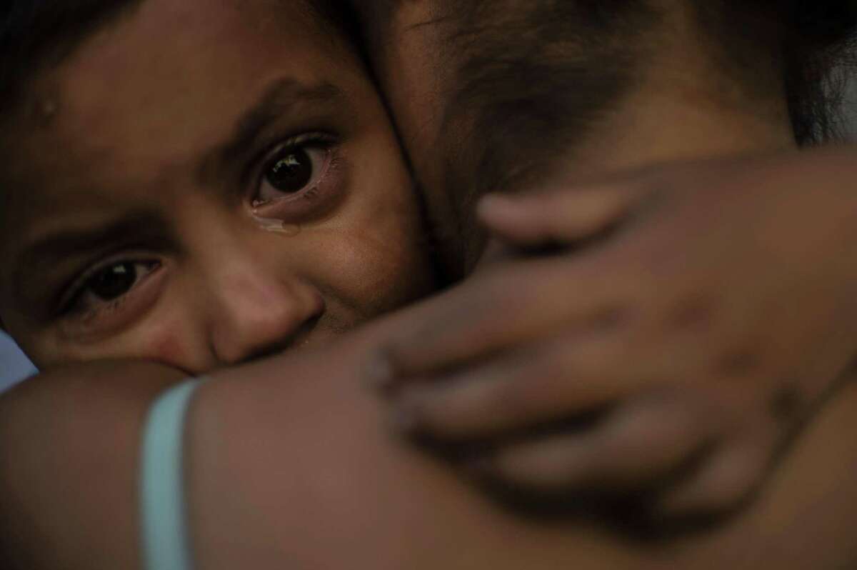 A Central American migrant child moving with a caravan towards the United States in hopes of a better life, cries as she embraces a woman at the Alfa y Omega shelter in Mexicali, Baja California state, Mexico, on November 16, 2018. - The Central American migrant caravan trekking toward the United States converged on the US-Mexican border Thursday after more than a month on the road, undeterred by President Donald Trump's deployment of thousands of American troops near the border. (Photo by PEDRO PARDO / AFP)PEDRO PARDO/AFP/Getty Images