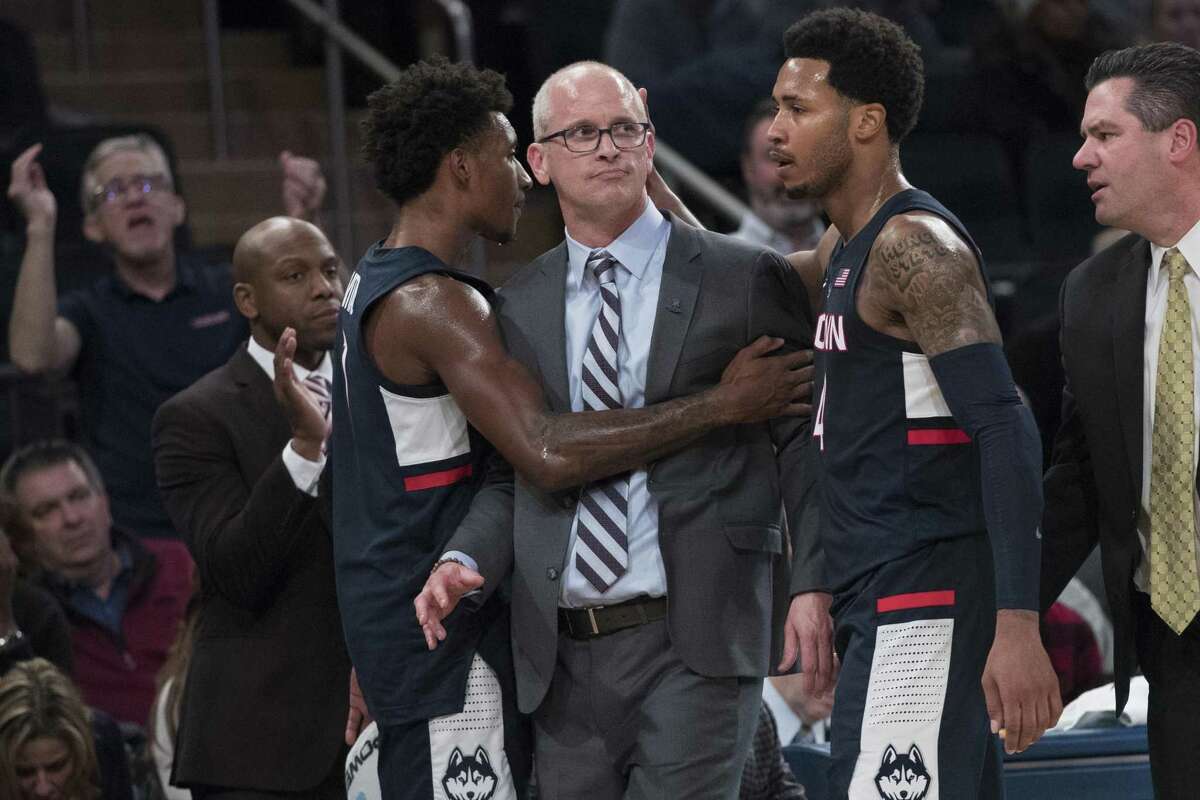 UConn’s Christian Vital, left, and Jalen Adams, right, console coach Dan Hurley after he was ejected in the closing minutes of the 2K Empire Classic championship on Friday at Madison Square Garden in New York.