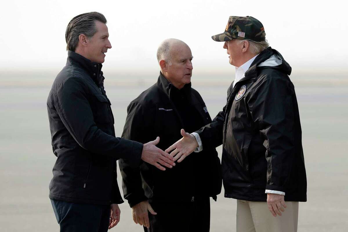 President Donald Trump greets California Gov.-elect Gavin Newsom as he arrives on Air Force One at Beale Air Force Base for a visit to areas impacted by the wildfires, Saturday, Nov. 17, 2018, at Beale Air Force Base, Calif., as Gov. Jerry Brown, stands at center.
