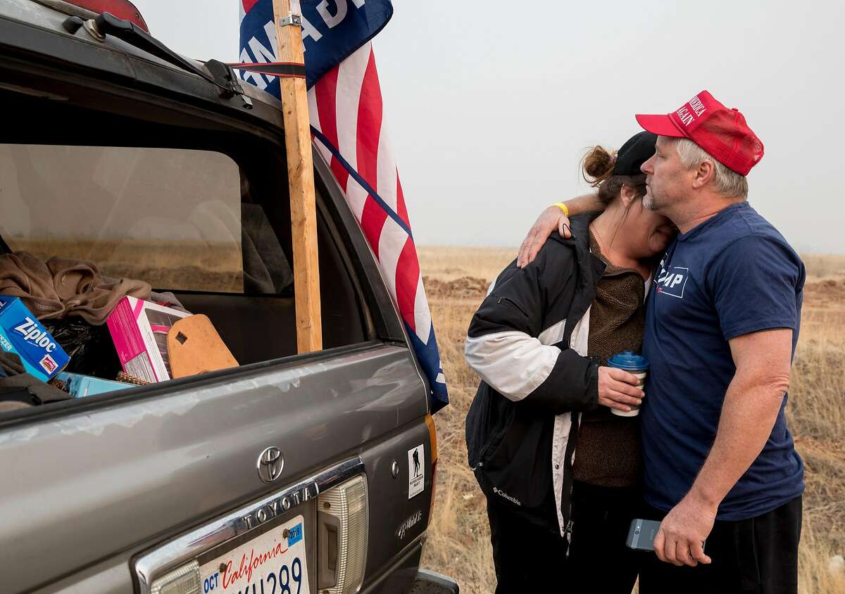 Paradise resident Fred Bowerman comforts his fianc�, Tami Wright, who lost their home in the Camp Fire, as emotions take over while waiting on the side of SkyWay in Chico, Calif. to get a glimpse of President Donald Trump as his motorcade drives into Paradise, Calif. Saturday, Nov. 17, 2018.