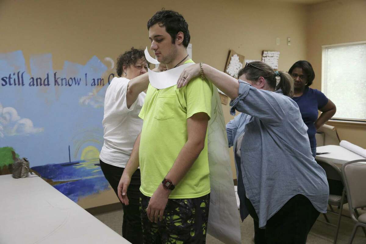 Carter Shute, 18, tries on a cape pattern during a cape-making workshop at Abiding Presence Lutheran Church, Sunday, November 4, 2018. The workshop was led by Sandy Liwang who is a volunteer with disABILITYsa, a nonprofit that provides programs, resources and volunteer opportunities to improve the lives of people with disabilities in San Antonio and help make the city more inclusive. The workshop is for families whose children are campaigning for next year's Fiesta Especial Royal Court.