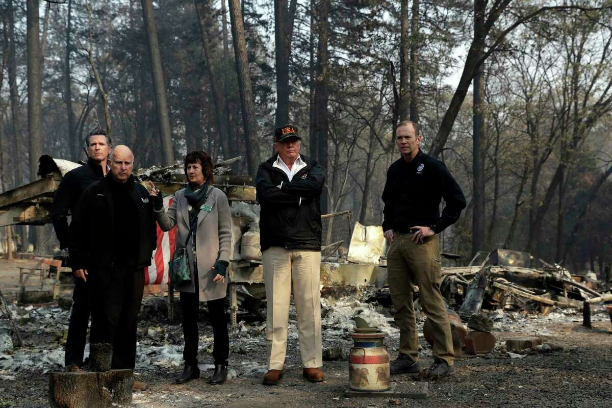 President Donald Trump talks with from left, Gov.-elect Gavin Newsom, California Gov. Jerry Brown, Paradise Mayor Jody Jones and FEMA Administrator Brock Longduring a visit to a neighborhood destroyed by the wildfires, Saturday, Nov. 17, 2018, in Paradise, Calif. (AP Photo/Evan Vucci)
