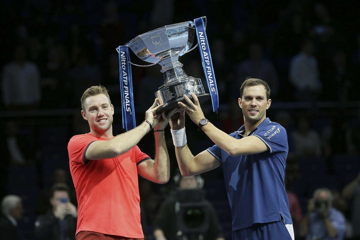 Mike Bryan, right, and Jack Sock of the United States hold up their trophy after defeating Pierre-Hugues Herbert and Nicolas Mahut of France during their ATP World Tour Finals doubles final tennis match at the O2 Arena in London, Sunday Nov. 18, 2018. (AP Photo/Tim Ireland)