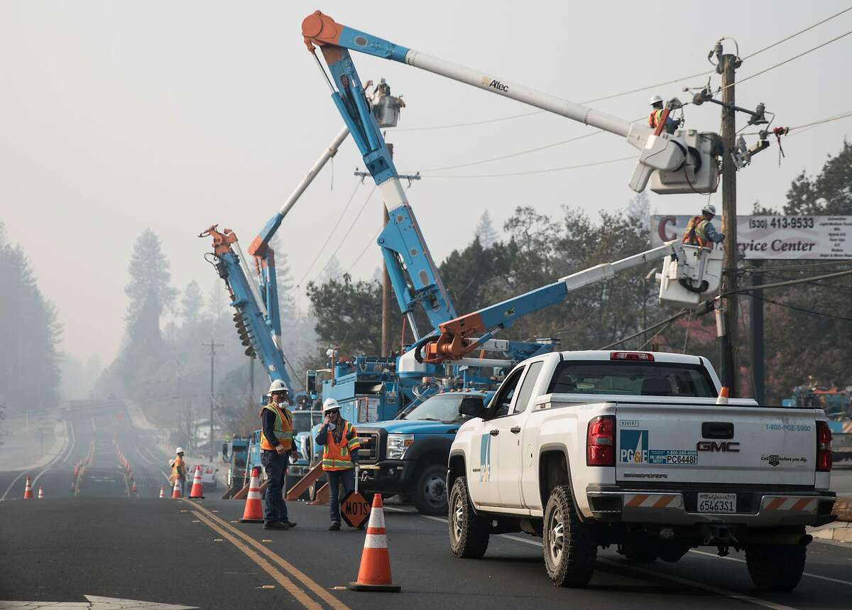 PG&E crews work to clear downed power lines and telephone poles in Paradise, Calif. Saturday, Nov. 17, 2018 after the Camp Fire ripped through the entire town.