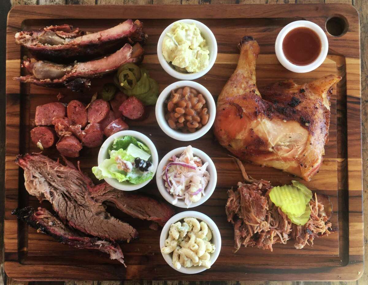The Smokin Joe's of Texas barbecue board includes (from top left): St. Louis-style pork ribs, potato salad, chicken leg quarter, pulled pork, macaroni salad, cole slaw, brisket, tossed green salad and sausage.