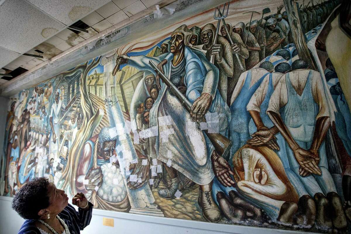 Charlotte Bryant looks at the John Biggers mural, "Contribution of Negro Women to American Life and Education" that was damaged in the aftermath of Hurricane Harvey, at the Blue Triangle Community Center on Wednesday, Nov. 7, 2018, in Houston. The historic mural was temporarily treated to prevent mold from spreading across it, but still needs extensive work to fully restore the work of art and the building in which it is housed.