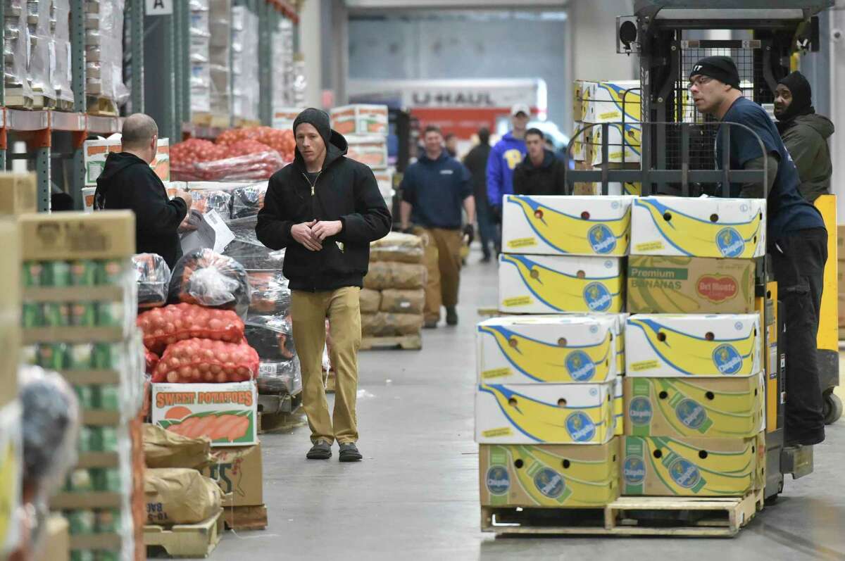 Wallingford, Connecticut - November 19, 2018: Connecticut Food Bank employee Joshua Maldonado drives a tow-motor stacked with food to be packed by volunteers that help fill community food program Thanksgiving orders and load the food orders in vehicles Monday at the Connecticut food Bank in Wallingford for Connecticut Food Bank member agencies.